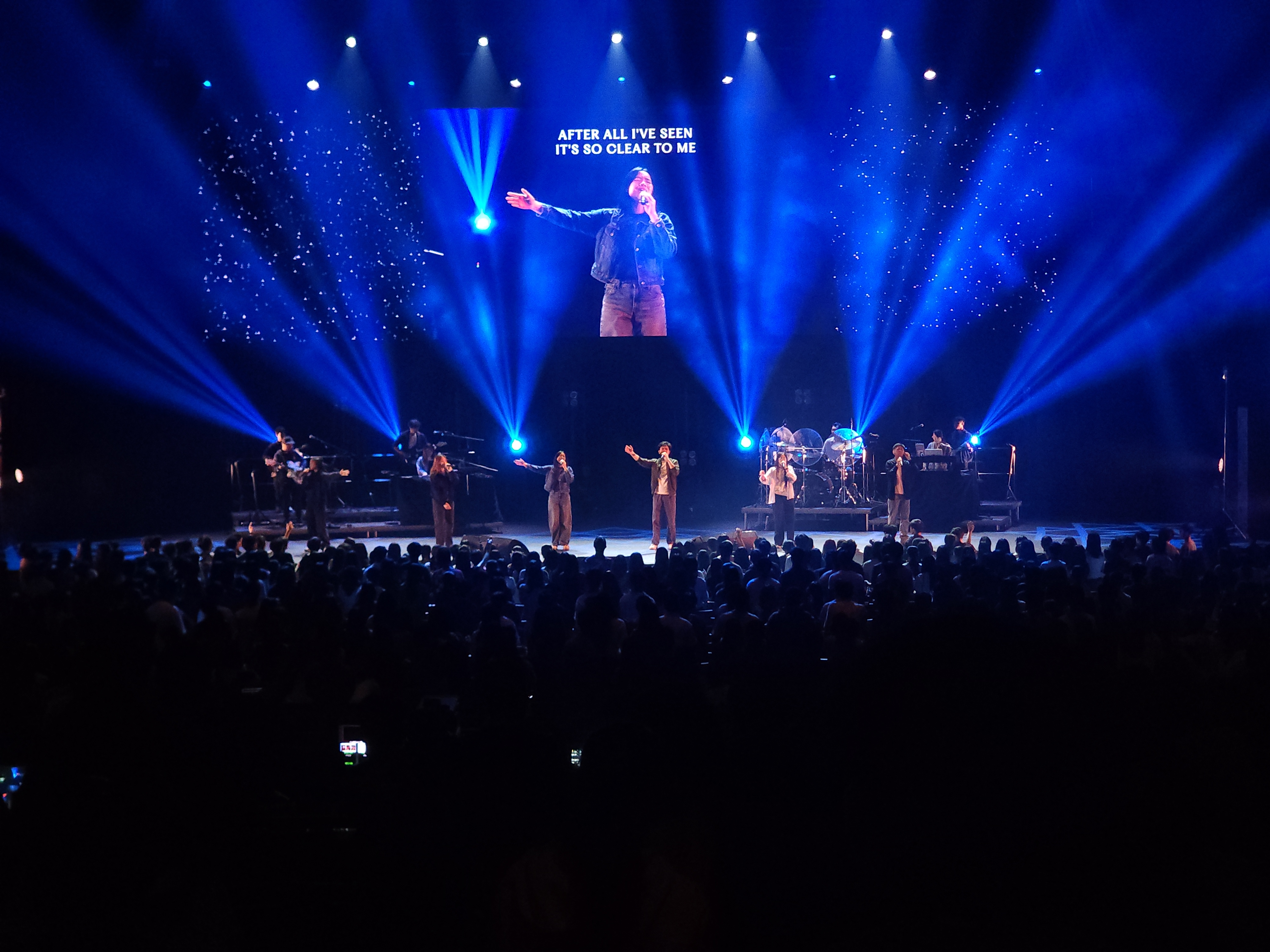 A wide concert stage washed in blue light
