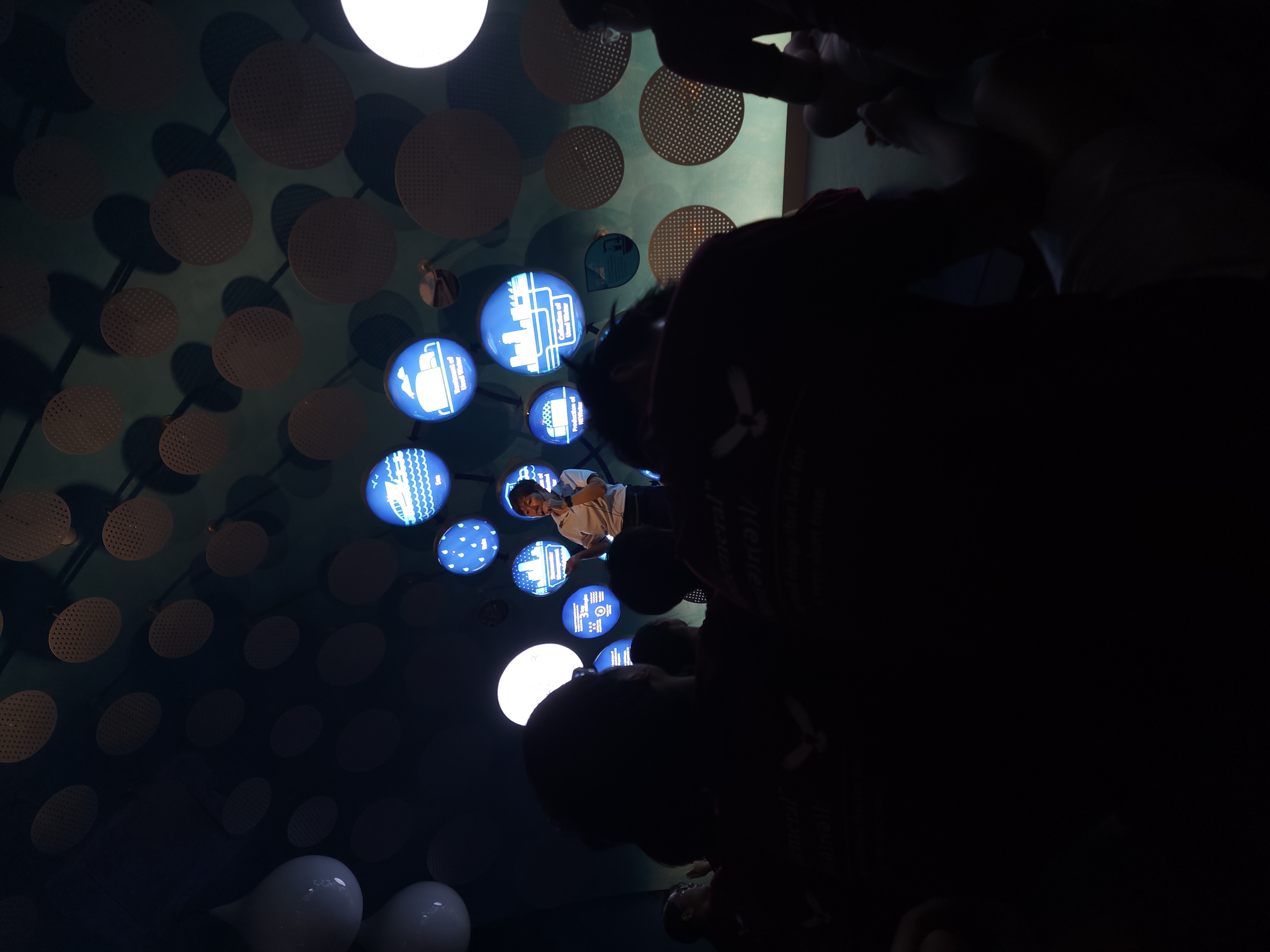A speaker framed by glowing blue exhibits at the NEWater Visitor Centre