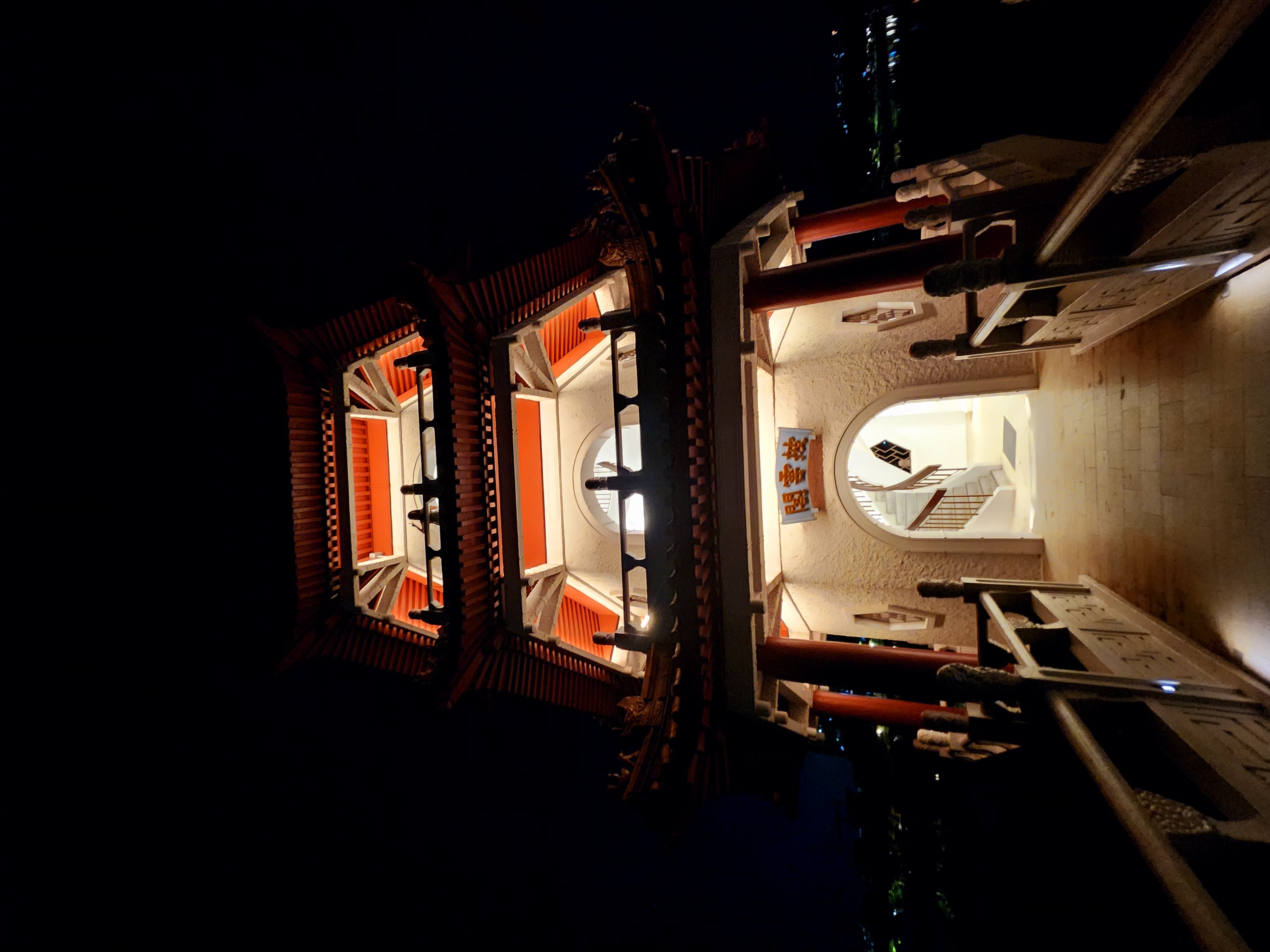A warmly lit pavilion photographed from below at night